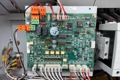 Płyta sterownika chillera Carrier w szafie elektrycznej sprawdzana podczas przeglądu