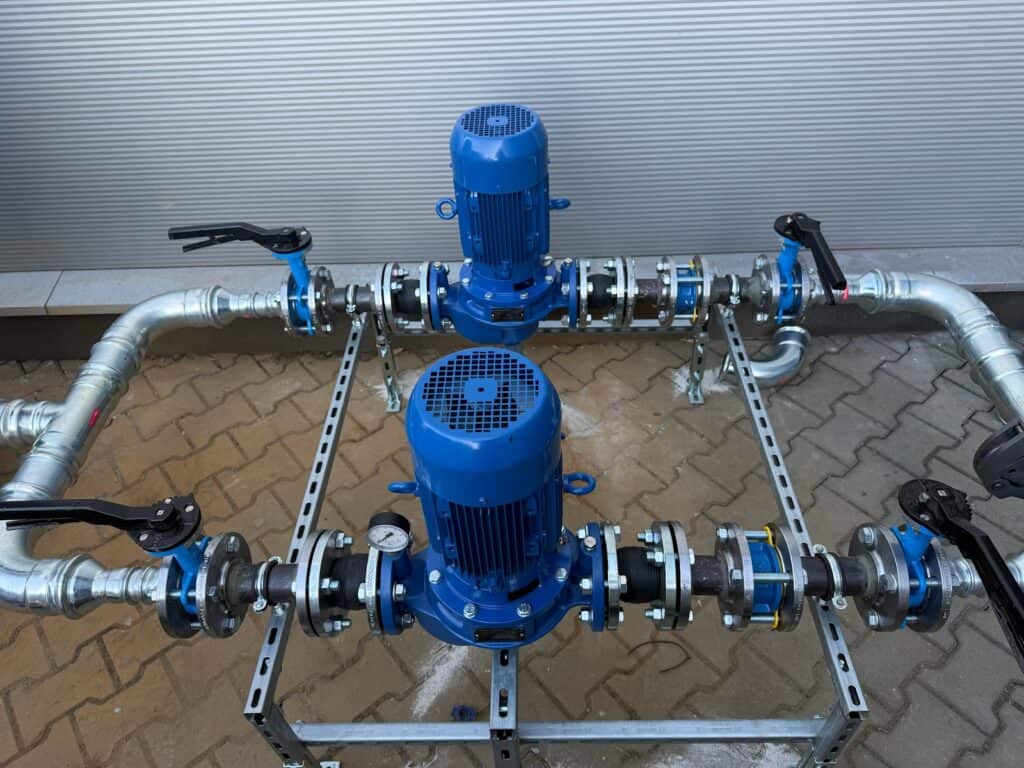 Pompa obiegowa z silnikiem elektrycznym i układem rur do instalacji chłodniczej.