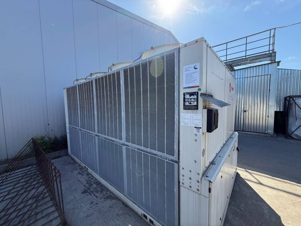 Duży wymiennik ciepła chłodniczy powietrza na zewnątrz budynku, element instalacji HVAC.