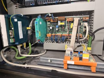 Panel sterowania z elementami elektrycznymi i przewodami w instalacji chłodniczej.