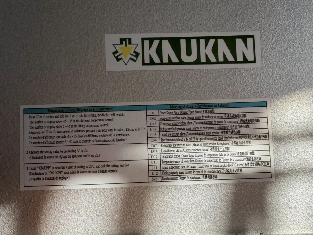 Naklejka z kodami alarmów E01 do E12 i ustawieniami temperatury na obudowie urządzenia